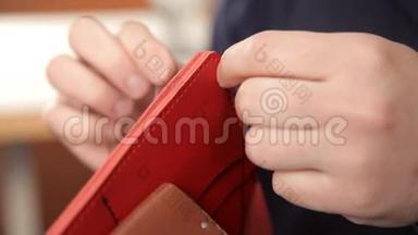 人用手做皮钱包.. 一个人在皮夹上缝针